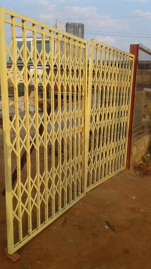 Yellow Collapsible Sliding Security Gate Installed at Building Entrance