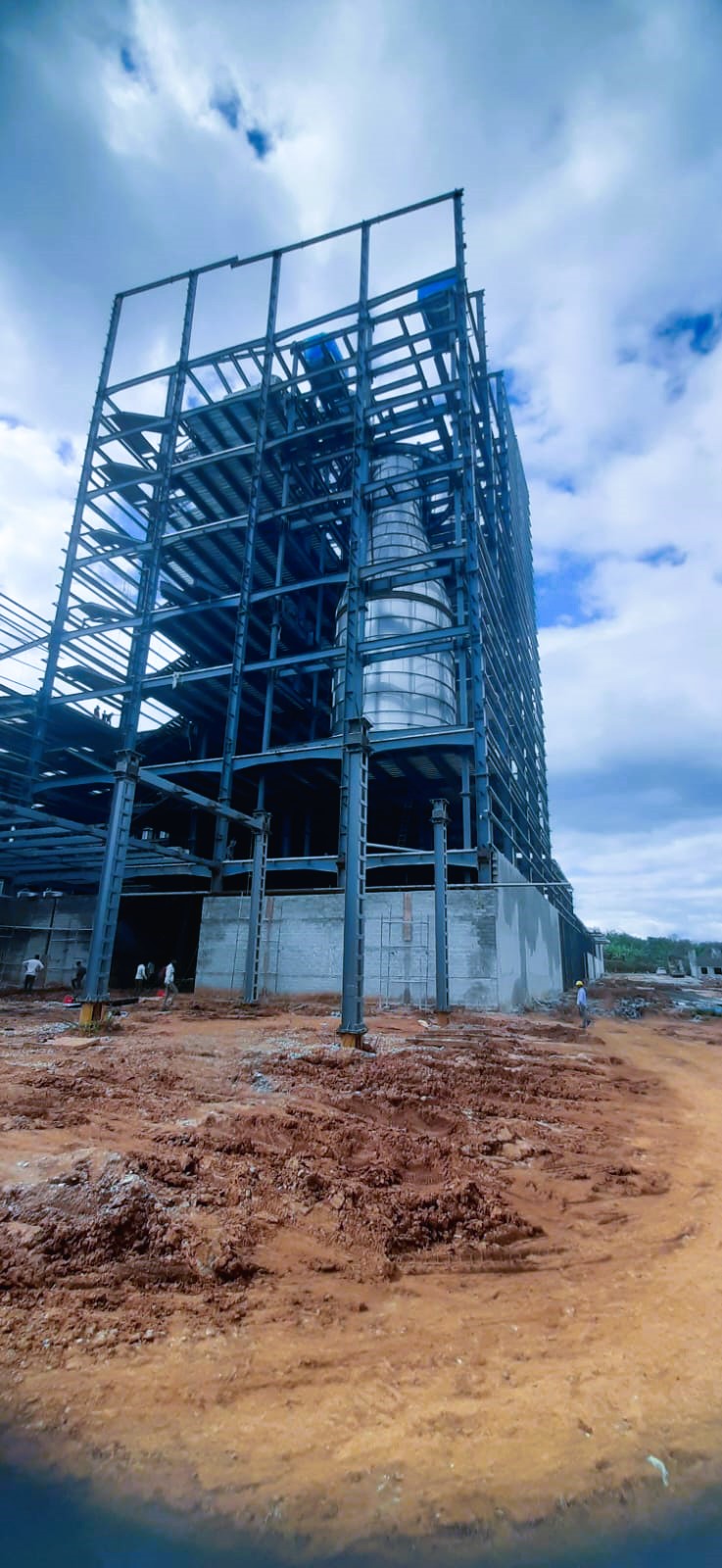Multi-story structural steel tower for industrial plant containing a large cylindrical chemical storage silo