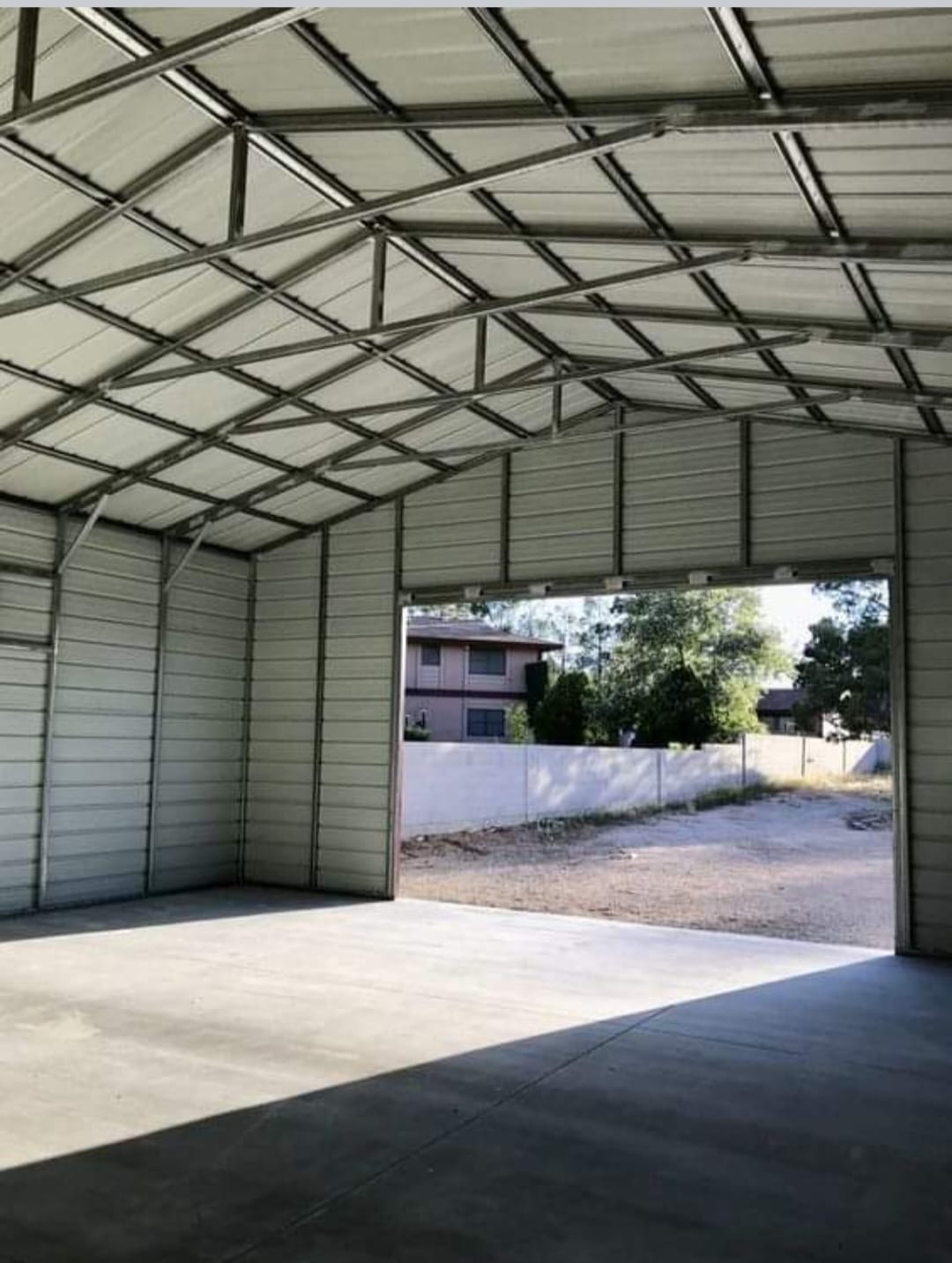 Interior view of a completed steel frame industrial shed building with corrugated wall cladding and open bay