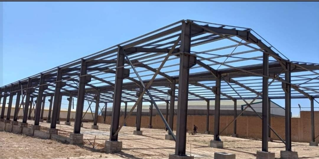 Pre-Engineered Building steel frame framework on concrete columns with brick wall background